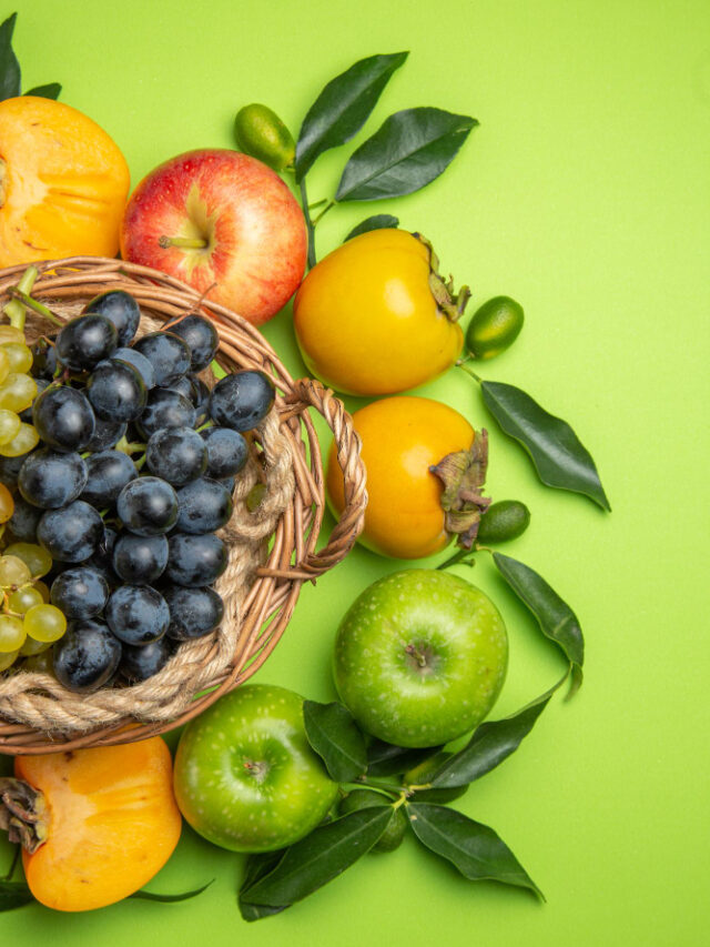 top-view-fruits-basket-bunches-grapes-persimmons-apples-with-leaves