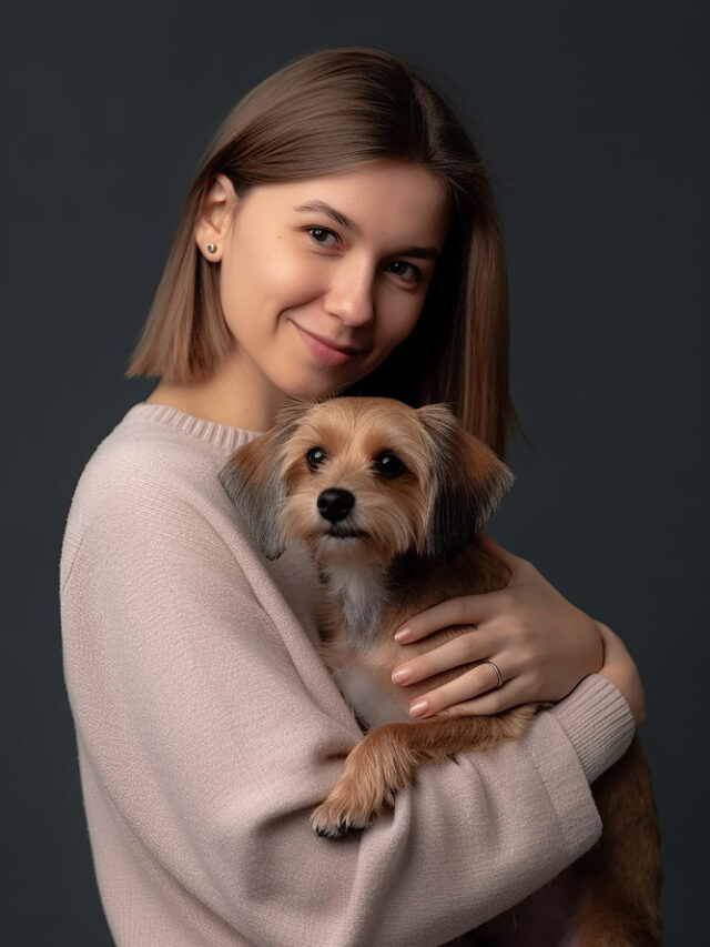 woman-holding-small-dog-her-arms-dark-studio-background