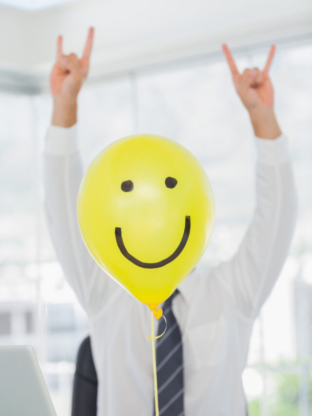 yellow-balloon-with-cheerful-face-hiding-rock-roll-businessman