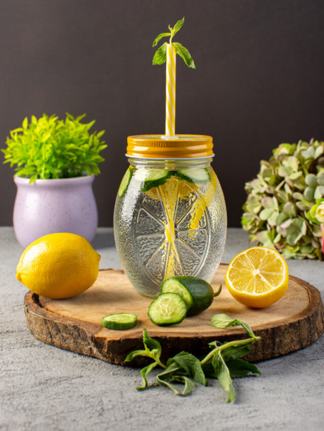 front-view-lemon-cocktail-fresh-cool-drink-inside-glass-cup-sliced-lemons-cucumbers-straw-wooden-desk-grey-background-cocktail-drink-fruit