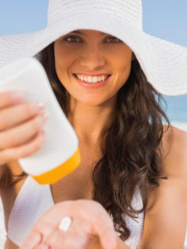 smiling-young-brunette-taking-care-her-body-putting-sun-cream